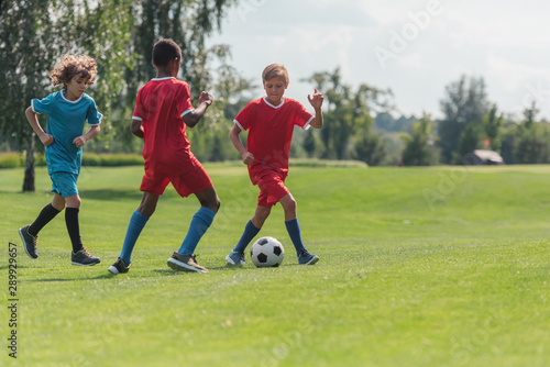 selective focus of multicultural children playing football