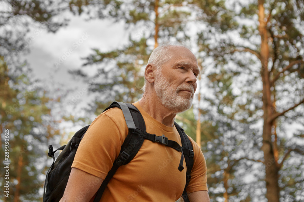Close up image of happy bearded Caucasian male traveler backpacking alone, having energetic look. Stylish active man backpacker hiking with rucksack, enjoying healthy lifestyle and cardio activity Close up image of happy bearded Caucasian male traveler backpacking alone, having energetic look. Stylish active man backpacker hiking with rucksack, enjoying healthy lifestyle and cardio activity