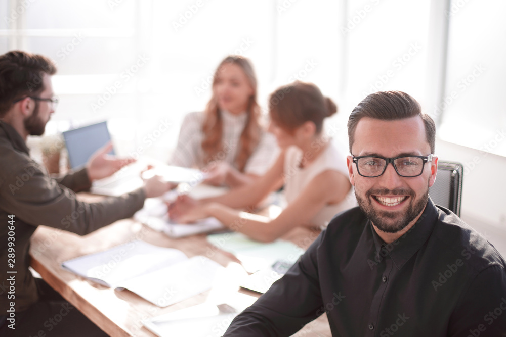 smiling businessman in the background of the office. smiling businessman in the background of the office.