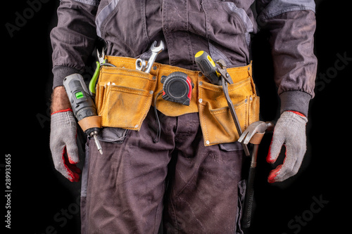 Production worker with tool belt. Screwdriver in worker kekek. photo