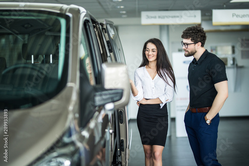 Young saleswoman working with client in car dealership. © F8  \ Suport Ukraine