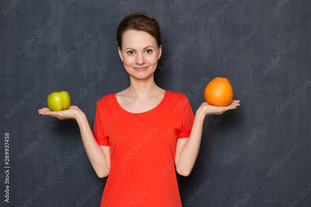 Portrait of happy girl holding apple and grapefruit in hands Portrait of happy girl holding apple and grapefruit in hands