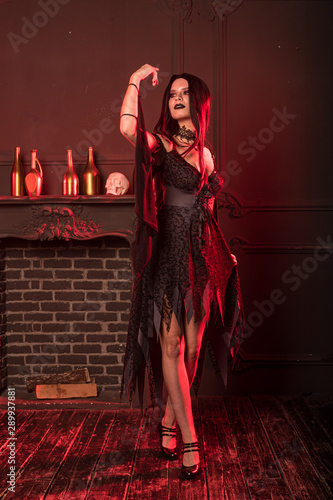  Charming witch in a dark room on Halloween