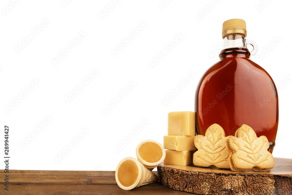Maple syrup bottle and maple products on a wooden plank. Copy space for your text. Cut out. Maple syrup bottle and maple products on a wooden plank. Copy space for your text. Cut out.