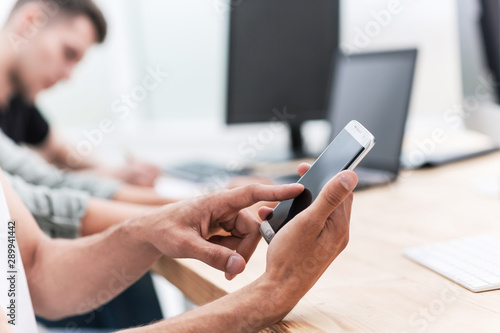 close up. businessman choosing a contact in his smartphone