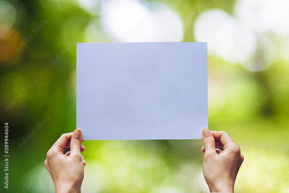 Show business paper in hand on nature background Show business paper in hand on nature background