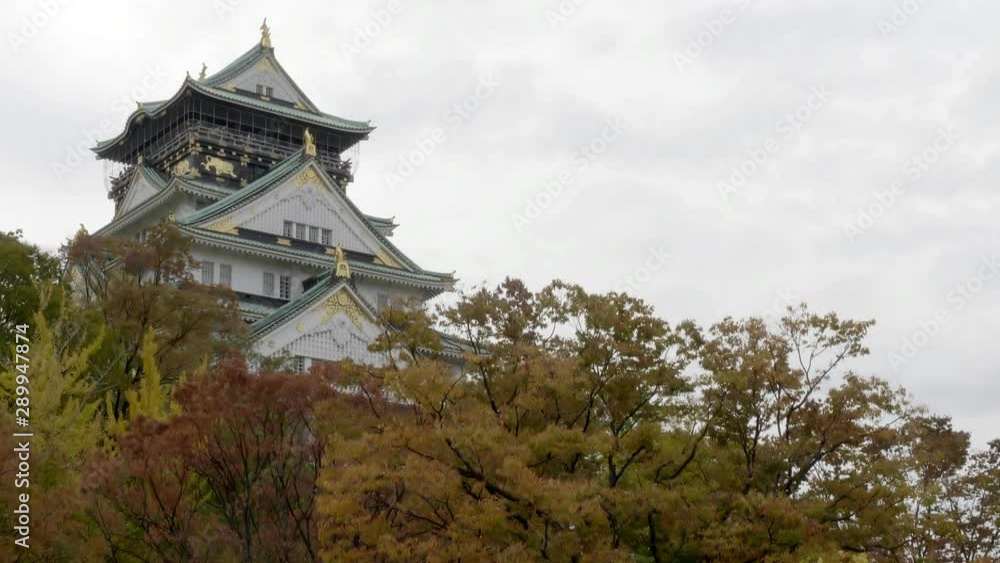 Famous Osaka Castle in Osaka, Japan. Autumn leaves on foreground trees. Famous Osaka Castle in Osaka, Japan. Autumn leaves on foreground trees.