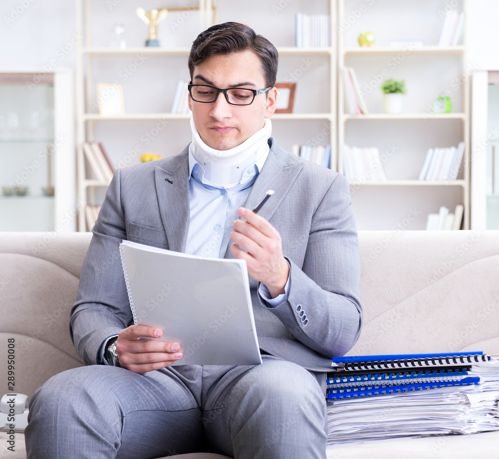 Man in neck brace cervical collar working from home teleworking Man in neck brace cervical collar working from home teleworking