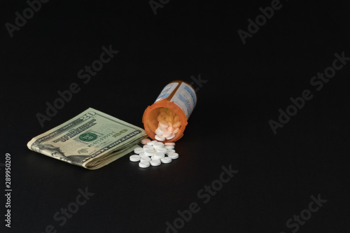 Prescription drugs pill bottle and money