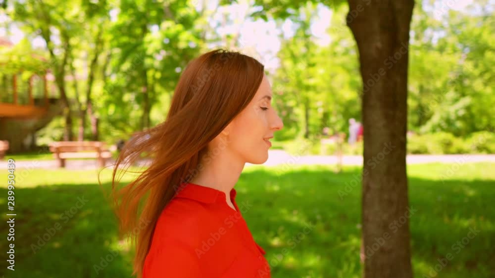 ginger woman in red shirt walking on the street outdoors background urban city view ginger woman in red shirt walking on the street outdoors background urban city view