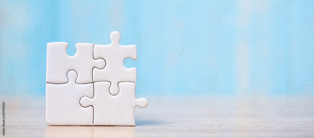 puzzle pieces on wood table background. Business solutions, mission target, successful, goals, cooperation, partnership and strategy concept - obrazy, fototapety, plakaty 