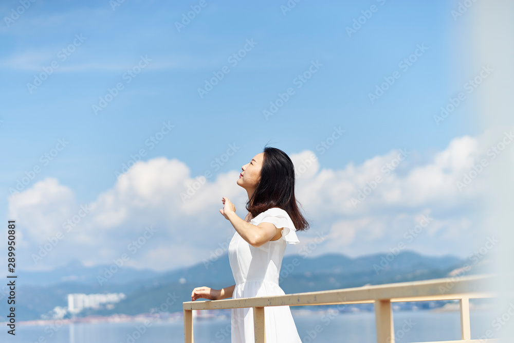 young asian woman looking up at sky