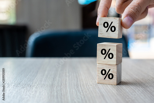 business man Hand putting wood cube block with percentage symbol icon. Interest rate, financial, ranking and mortgage rates concept