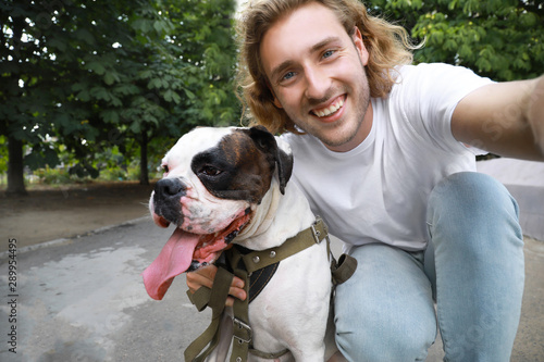 Young man with cute dog tak...