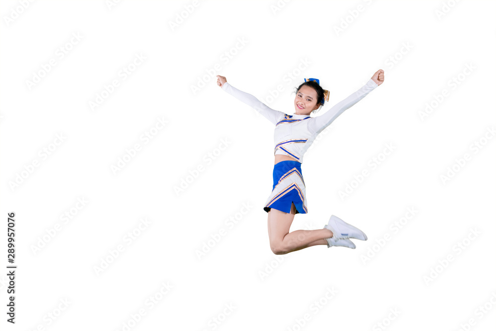 Beautiful cheerleader leaping with copy space