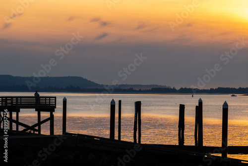 Sunset at Coos Bay Oregon Empire dock. Silhouetted wood pilings, industrial fishing wharf.