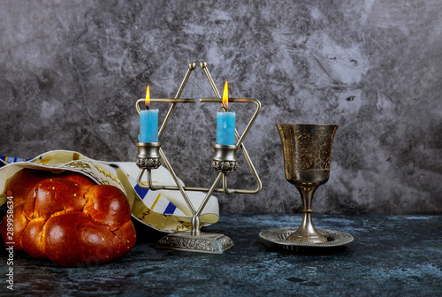 Sabbath Jewish Holiday challah bread and candelas on wooden table