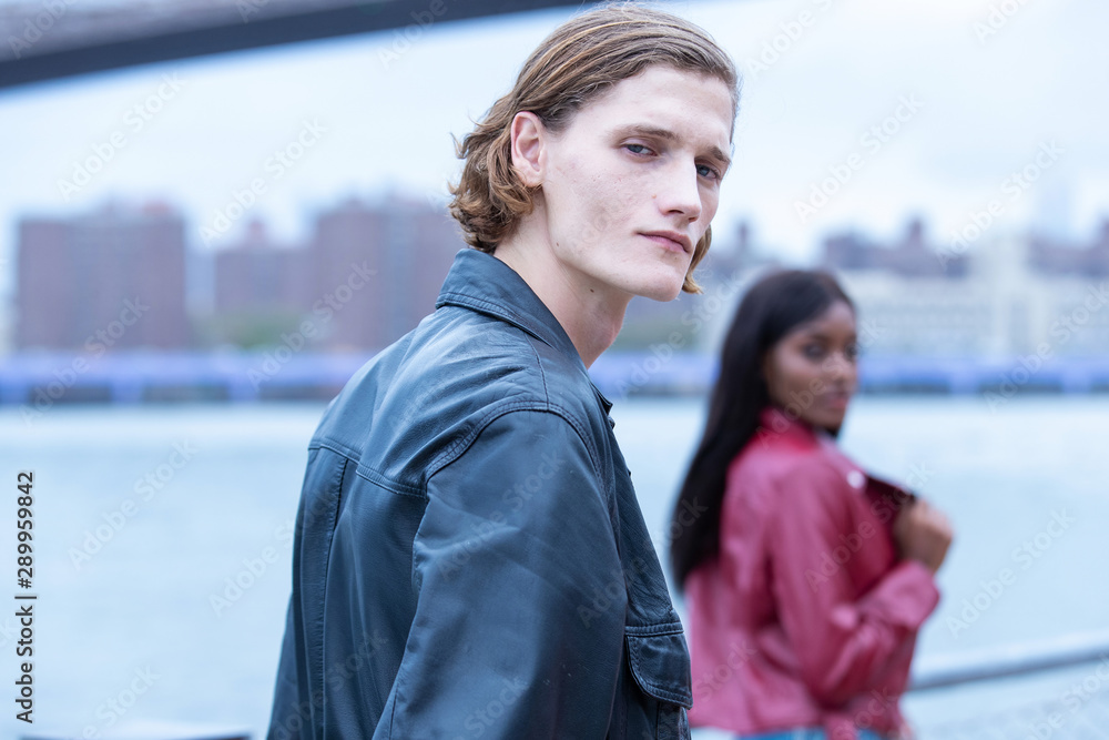 Handsome man in city with woman out of focus in background