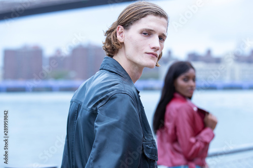 Handsome man in city with woman out of focus in background