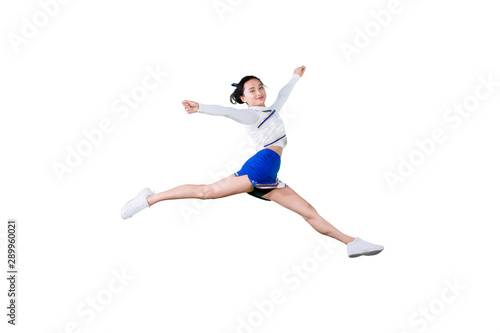 Young female cheerleader jumping in the studio