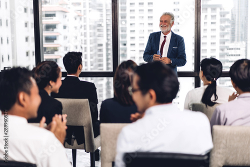 Businessman standing in front of group of people in consulting meeting conference seminar at hall or seminar room.presentation and coaching concept