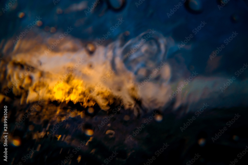 Fototapeta premium Abstract image of an orange sunset. Shot made through the wave.