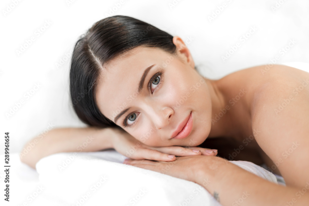 Beautiful young woman beauty skin treatment relaxing lying on towel in massaging and spa salon Beautiful young woman beauty skin treatment relaxing lying on towel in massaging and spa salon