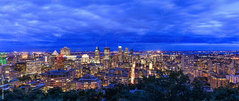Montreal view at sunrise or sunset time with blue sky. Panoramic skyline of Canadian city. Beautiful night clouds over Montreal downtown buildings. Amazing town panorama in the evening.