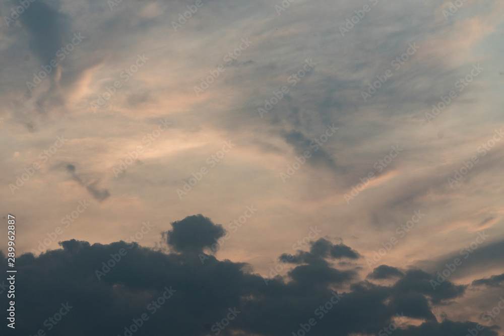 Background image of blue sky with clouds. Sunlight breaking through the clouds