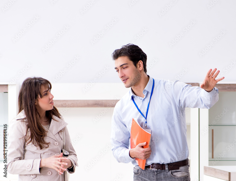 Fototapeta premium Salesman explaining to woman customer at furniture store