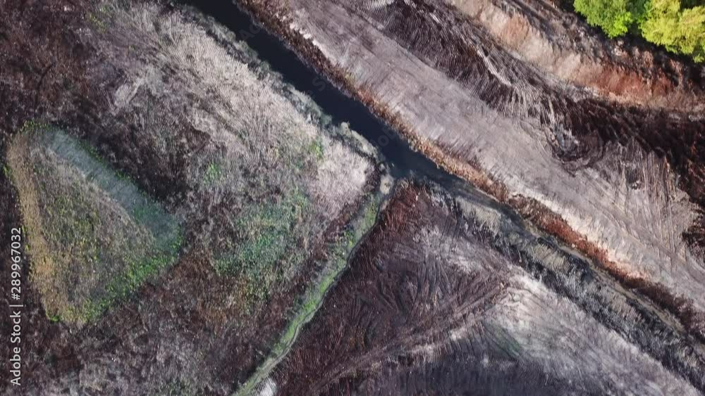 Aerial shot flyover earthwork excavation site next to green forest. TOP DOWN Aerial shot flyover earthwork excavation site next to green forest. TOP DOWN