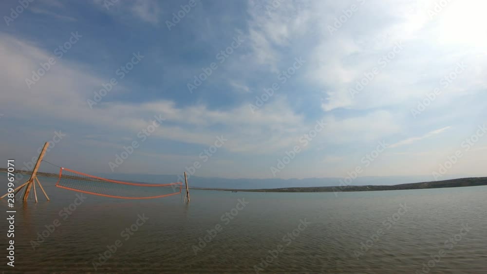 Early morning on a sandy beach with volleyball net ready for players Early morning on a sandy beach with volleyball net ready for players