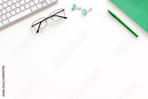 Creative work desk with green supplies on white background flat lay copy space top view