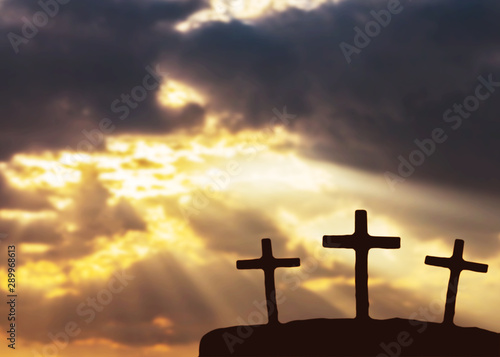 Close up of tree isolated black cross on the hill over blurred sunset sky background