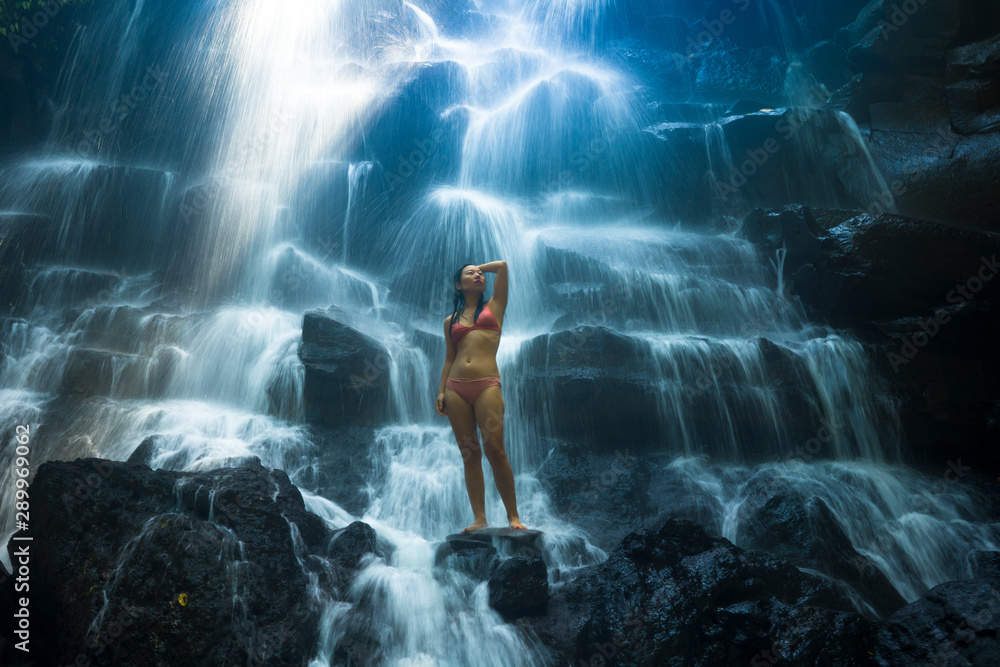 Obraz premium natural portrait of young beautiful and happy Asian Korean woman in bikini enjoying nature at tropical paradise waterfall with magical feeling in soul inspiration