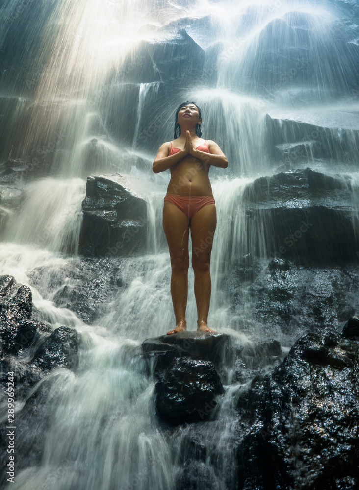 Obraz premium natural portrait of young beautiful and happy Asian Korean woman in bikini enjoying nature at tropical paradise waterfall with magical feeling in soul inspiration