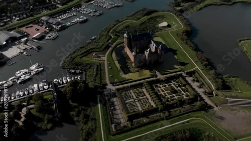 Aerial backingup revealing the lush gardens of the Muiderslot castle and wider port area of Muiden near Amsterdam at the IJsselmeer photo