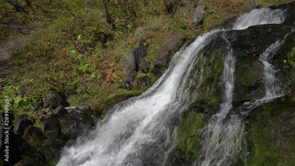 Cascade of alpine waterfall with crystal clean and clear water flowing from snowfields and glaciers in mountains. Scenery autumn view of environment landscape. Concept: lack of clean drinking water. Cascade of alpine waterfall with crystal clean and clear water flowing from snowfields and glaciers in mountains. Scenery autumn view of environment landscape. Concept: lack of clean drinking water.