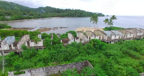 Resort Ruins on Coral Coast Fiji at Korolevu. Jungle reclaiming housing and accommodation next to lagoon. photo