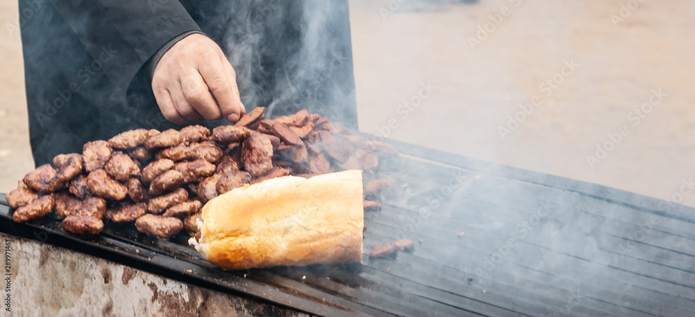 Man picking Camel meat from barbecue during Camel wrestling festival. Man picking Camel meat from barbecue during Camel wrestling festival.