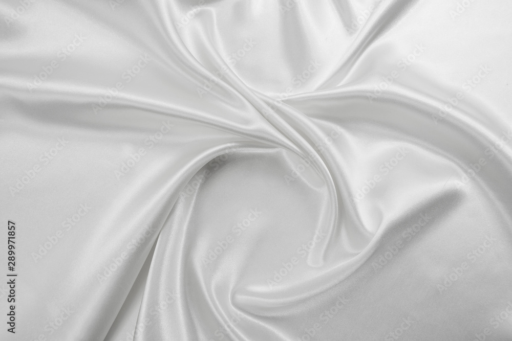 Fototapeta premium Delicate satin draped fabric white texture for festive backgrounds