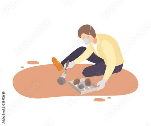 Male Archaeologist Sitting on Ground and Sweeping Dirt from Stones Using Brush, Paleontology Scientist Character Working on Excavations with Historical Artifacts Flat Vector Illustration