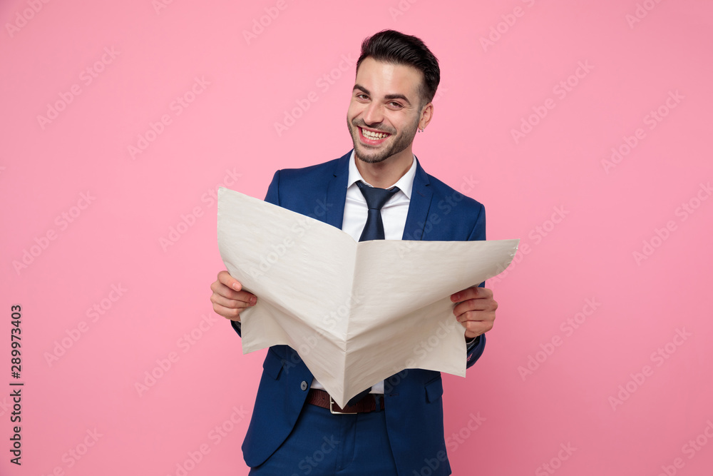 handsome young man reading newspaper on pink background handsome young man reading newspaper on pink background