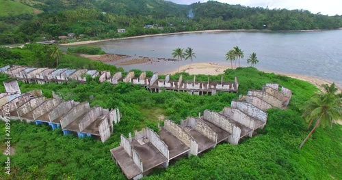 Resort Ruins on Coral Coast Fiji at Korolevu. Jungle reclaiming housing and accommodation next to lagoon. photo