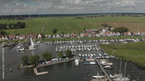 Aerial backing up showing the marine port area for pleasure boats and sailboats with typical houses of the Dutch village of Durgerdam at the Durgerdammerdijk near Amsterdam on an overcast day photo