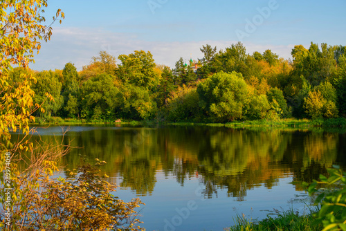early autumn - trees beginning to turn yellow and reflection in the river
