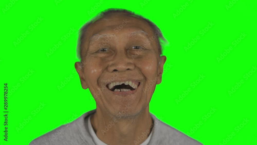 Elderly man laughing in the studio with detached dentures and wrinkled skin. Shot in 4k resolution with green screen background Elderly man laughing in the studio with detached dentures and wrinkled skin. Shot in 4k resolution with green screen background