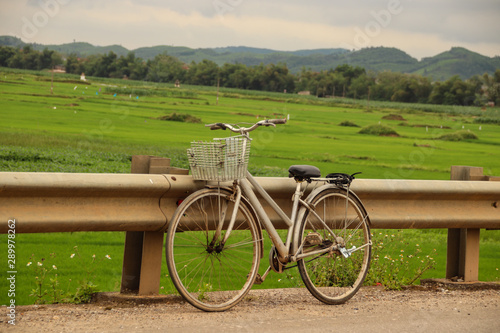 An oma fiets or granny bike parked at the side of the road against the scenic countryside of Phong nha Vietnam photo