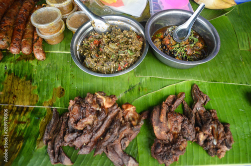 Lao sausage or sou oa, grilled chicken or ping gai, and Lao barbecue or sindad sold as traditional street food in the Luang Prabang morning market in Laos © MarieXMartin