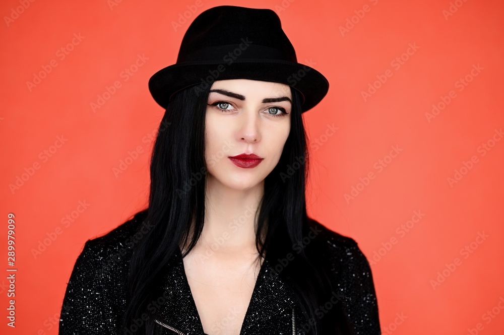 Concept close-up portrait of a pretty brunette girl in a hat on a colorful background in the studio. Concept close-up portrait of a pretty brunette girl in a hat on a colorful background in the studio.